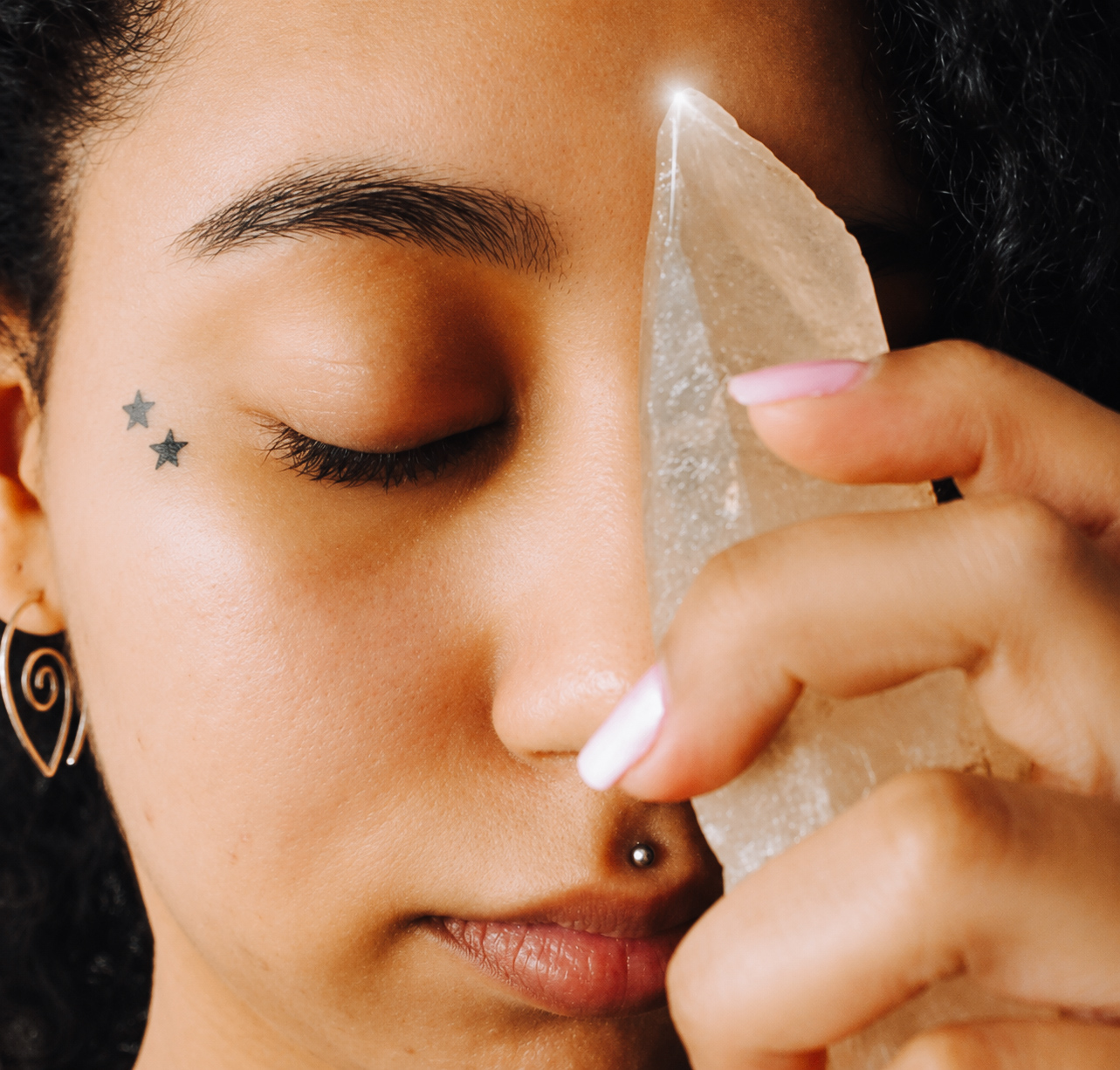 Zen holding a clear crystal near her third eye